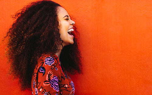 Laughing african young woman with curly hair