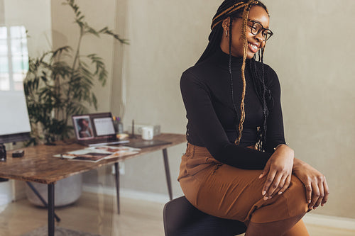 Creative young woman smiling while sitting alone