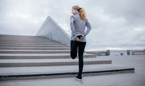 Fitness woman stretching before jogging