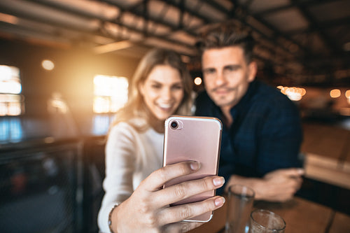 Couple taking selfie at bar