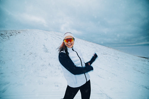 In a snowy landscape, the woman trains with playful energy during her winter workout