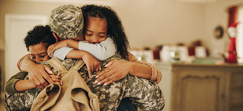 Soldier embracing his wife and kids on his homecoming