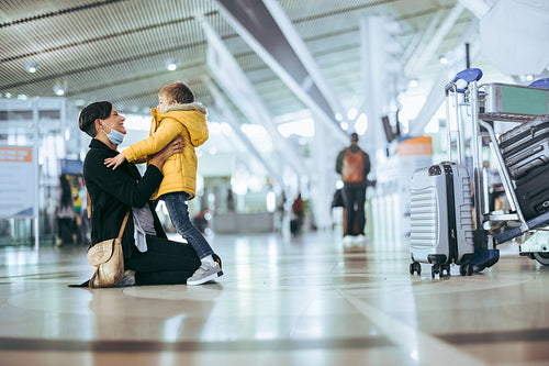 Happy woman meeting son at airport arrivals