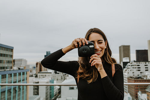 Woman taking pictures with an instant camera