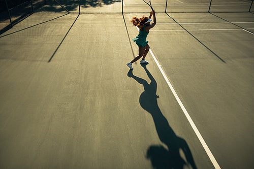 Tennis player silhouette on court during sunset session rally