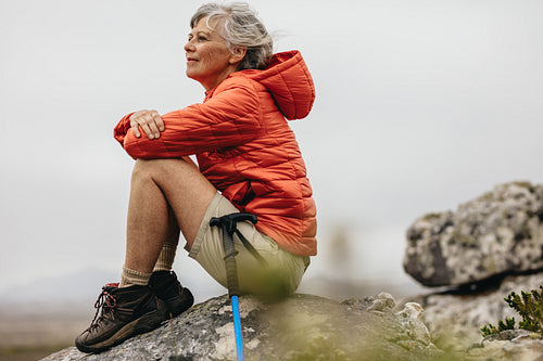 Female trekker sitting on a rock relaxing
