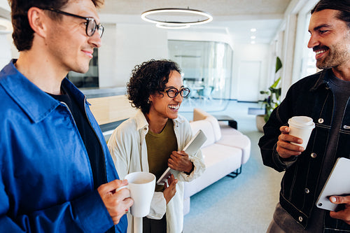 Three business professionals share coffee and ideas