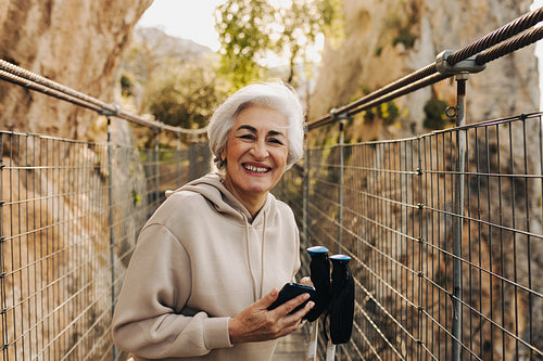 Happy senior woman going for a leisurely hike outdoors