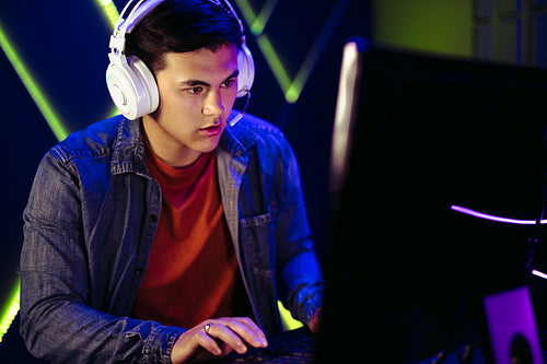 Male gamer engaging in a pc video game session with a headset