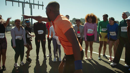 Fitness trainer hypes up his team before they run a race together