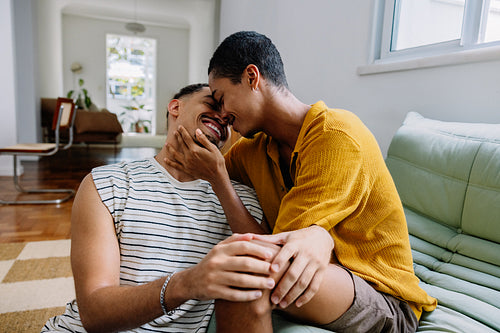 Two men sharing laughter and affection on the living room floor