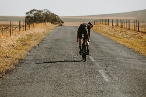 Professional cyclist riding bicycle on countryside road