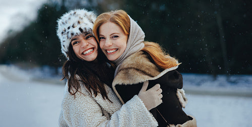 Snowy women share a hug with best friends outdoors