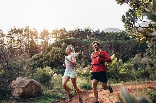 Athletic couple running together in a park