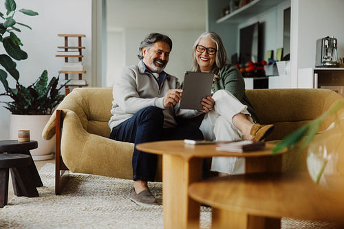 Senior couple uses a tablet together at home