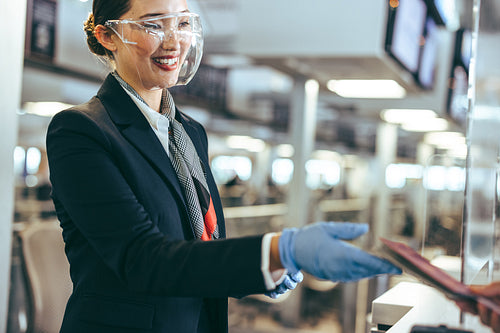 Woman working at airline check-in counter during pandemic