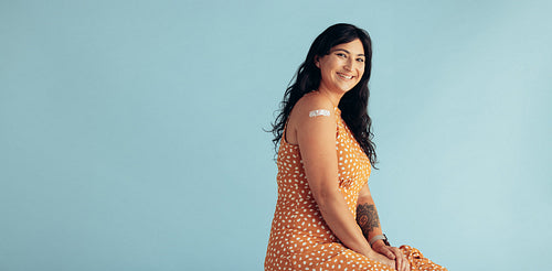 Woman with band-aid on arm after getting vaccine