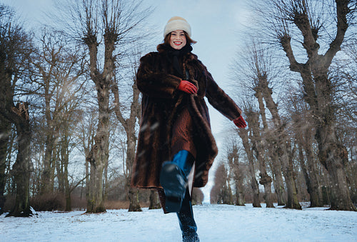 Walking women cross a snowy park with friends