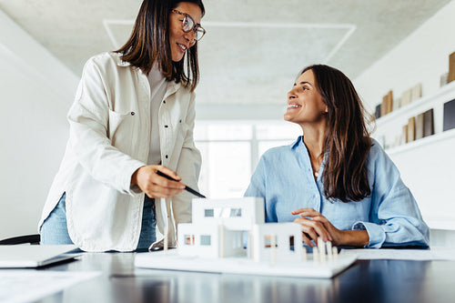 Female architects working on a house model in an office