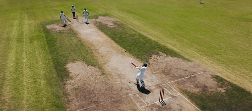 Cricket batsman swinging for a six over the boundary during a competitive match