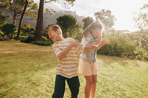 Children playing in the outdoors splashing water and enjoying the sunny day