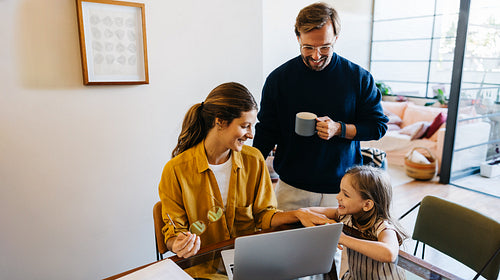 Family moment at home with laptop and coffee
