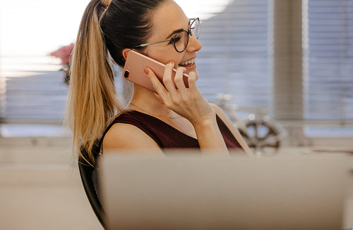 Young woman in office talking on phone