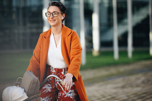 Mature business woman riding a bike and listening to music on her way to work