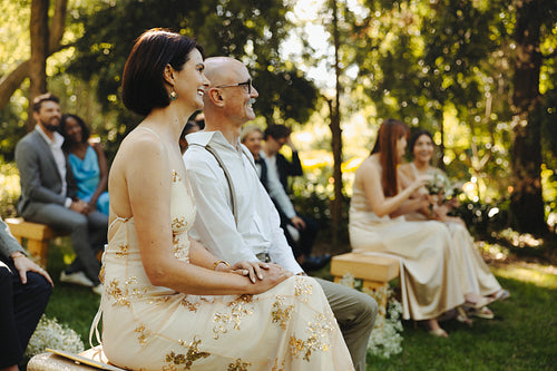 Guests enjoying an outdoor wedding ceremony in a beautiful garden setting