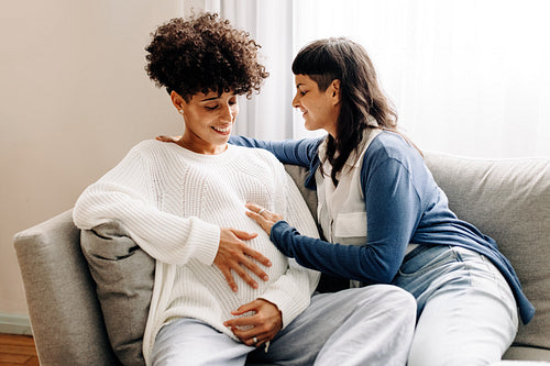 Female parents-to-be sitting together at home