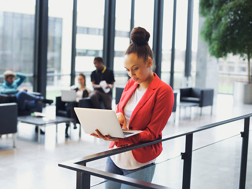 Young african woman using laptop in office