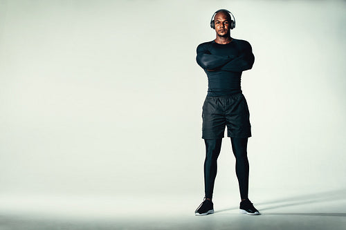 Muscular and fit male model standing on grey background