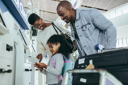 Tourist family doing self service check-in for flight
