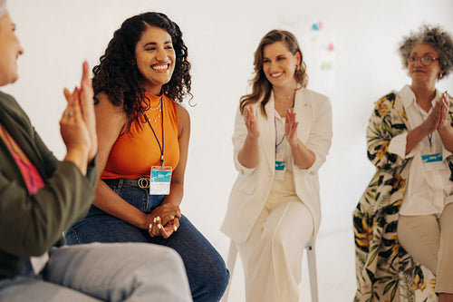 Happy businesswomen applauding their team mate during a meeting