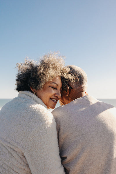 Elderly woman smiling happily while sitting with her husband