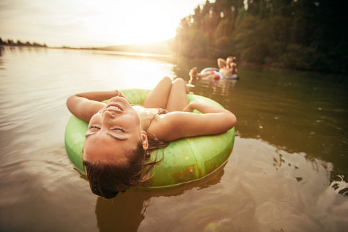 Young woman relaxing on inflatable ring in lake