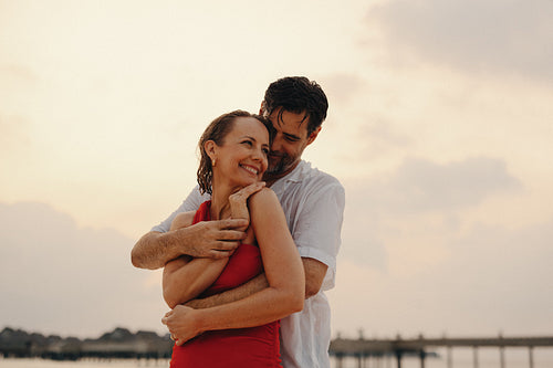 Mature couple embracing at sunset on a picturesque island