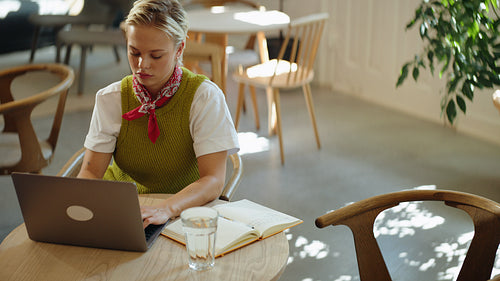 Women collaborate on laptop work during a business meeting at a cafe table