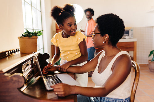 Mother and daughter sharing quality time using laptop at home