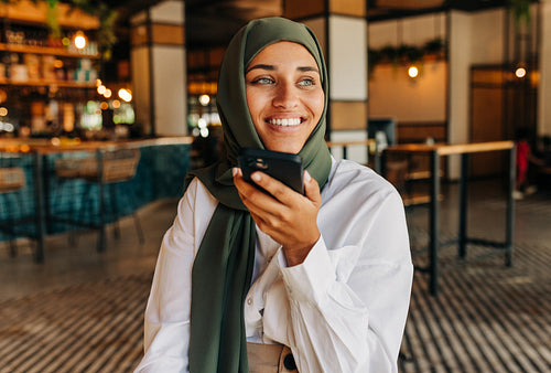 Muslim businesswoman taking a phone call in a cafe