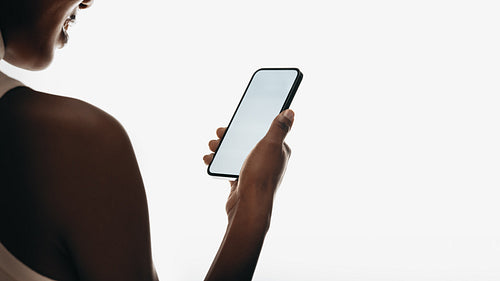 Woman holding a smartphone with a clean white background