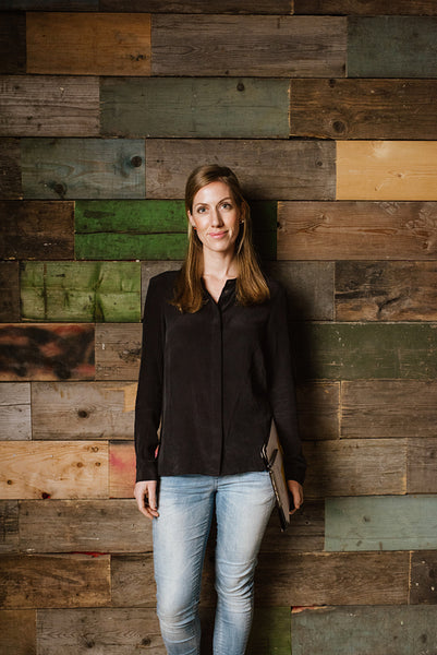 Attractive young woman standing against a wooden wall in office