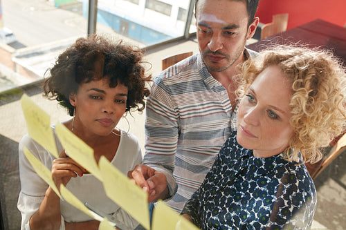 Coworkers discussing new ideas on a glass wall