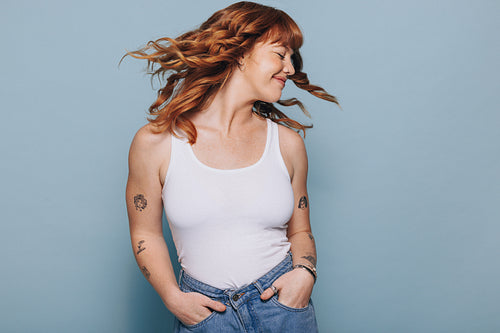Young woman flipping her ginger hair in a studio