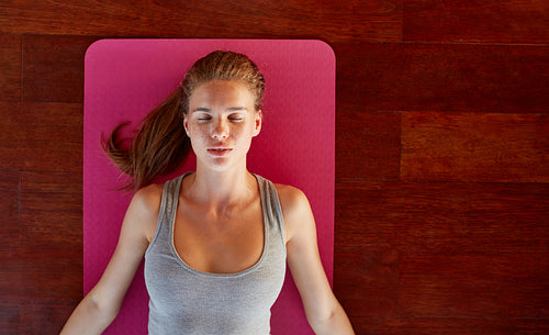 Fitness woman in corpse pose at gym