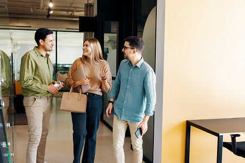 Young adults walking and conversing together in a bright modern office setting