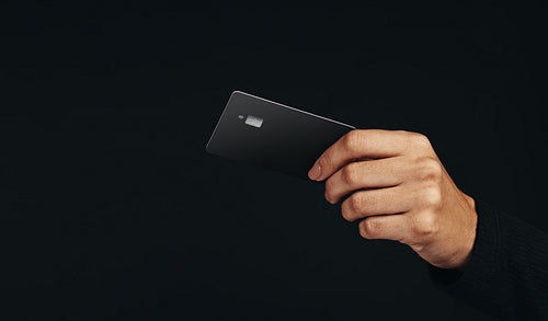 Black premium credit card. Stock photo of female shopper pays with her black, premium credit card in a studio