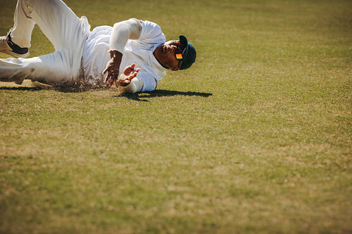 Cricket player fielding during a match on a sunny day