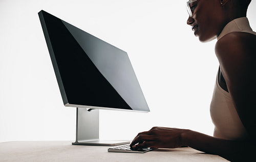 Professional workspace setup with computer and focused person on minimalistic desk