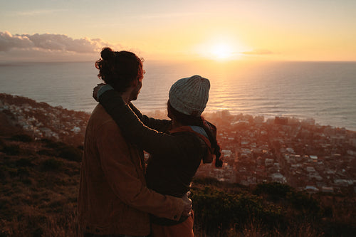 Romantic couple admiring the sunset from peak